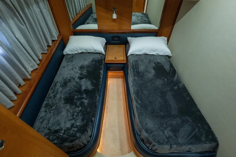 Slide: The Image of Twin beds in a 2008 Azimut 62E yacht cabin with plush gray bedding. - 27