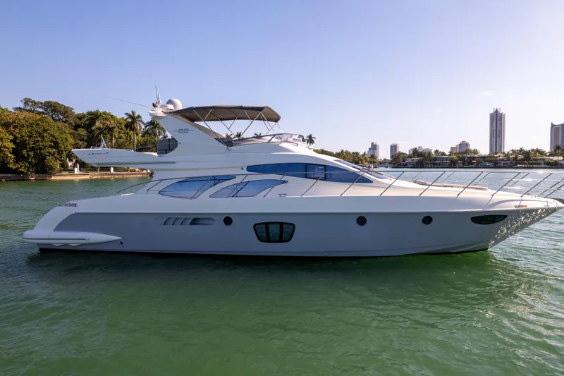 Slide: The Image of 2008 Azimut 62E yacht on calm water with city skyline background. - 4