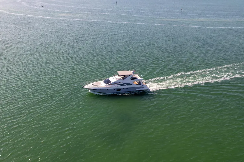 Slide: The Image of 2008 Azimut 62E yacht cruising on open water, leaving a gentle wake. - 8