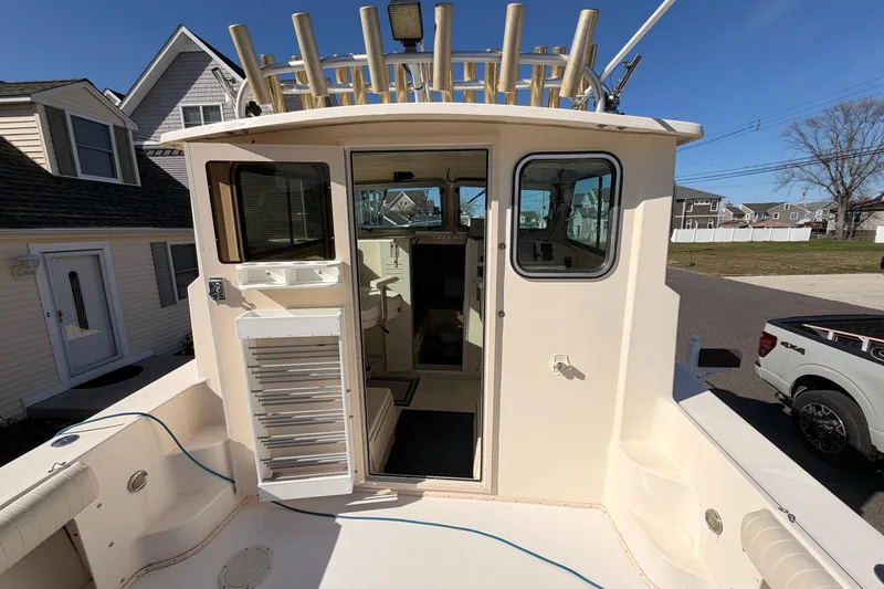 Slide: The Image of 2004 Parker 2520 XL Sport Cabin boat docked near residential homes. - 13