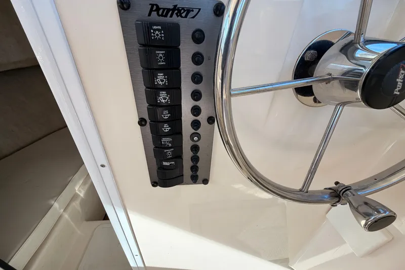 Slide: The Image of Control panel and steering wheel of a 2004 Parker 2520 XL Sport Cabin boat. - 15