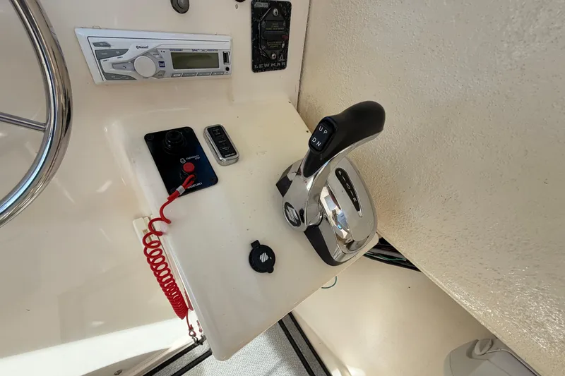 Slide: The Image of Control panel of a 2004 Parker 2520 XL Sport Cabin boat with throttle and radio. - 16