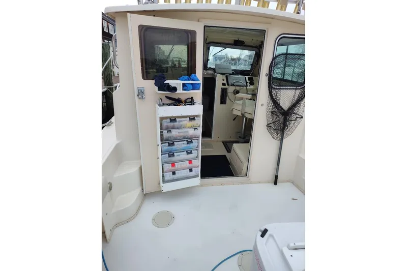 Slide: The Image of 2004 Parker 2520 XL Sport Cabin boat interior with fishing gear and storage. - 23