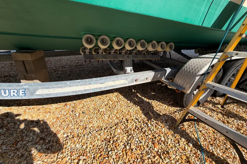 Slide: The Image of Trailer supporting a 2004 Parker 2520 XL Sport Cabin boat on gravel. - 26