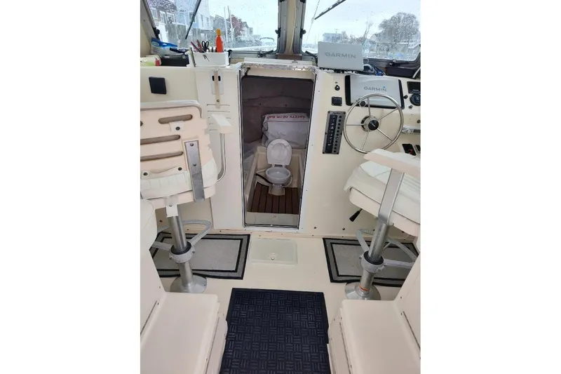 Slide: The Image of 2004 Parker 2520 XL Sport Cabin interior with helm, seating, and marine toilet. - 6