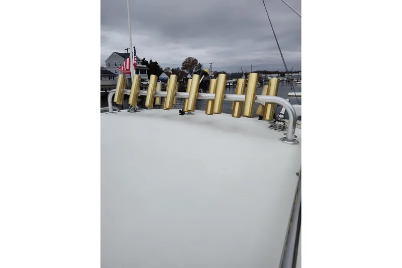 Slide: The Image of 2004 Parker 2520 XL Sport Cabin boat with gold rod holders on deck. - 9