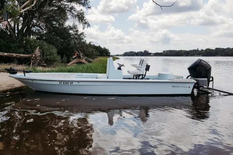 The Image of 2025 East Cape 25 Hybrid boat docked by a scenic riverside. - 0