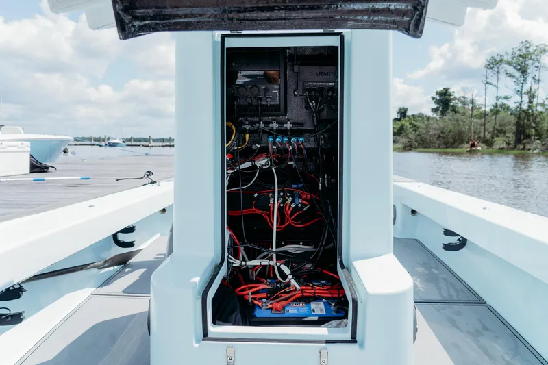 Slide: The Image of 2025 East Cape 25 Hybrid boat electrical compartment with wiring and components, dockside view. - 10