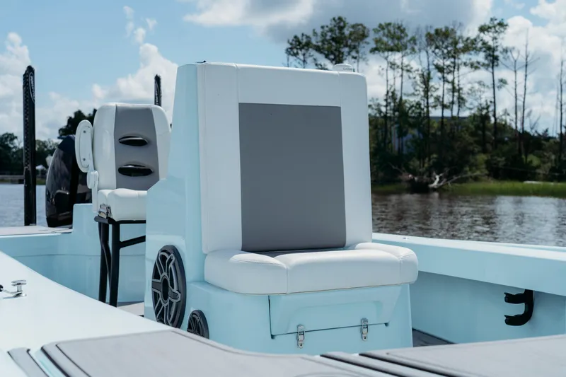 Slide: The Image of 2025 East Cape 25 Hybrid boat interior with seating and speaker, on a calm waterway. - 12
