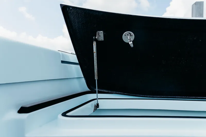 Slide: The Image of Open storage compartment on 2025 East Cape 25 Hybrid boat under a blue sky. - 2