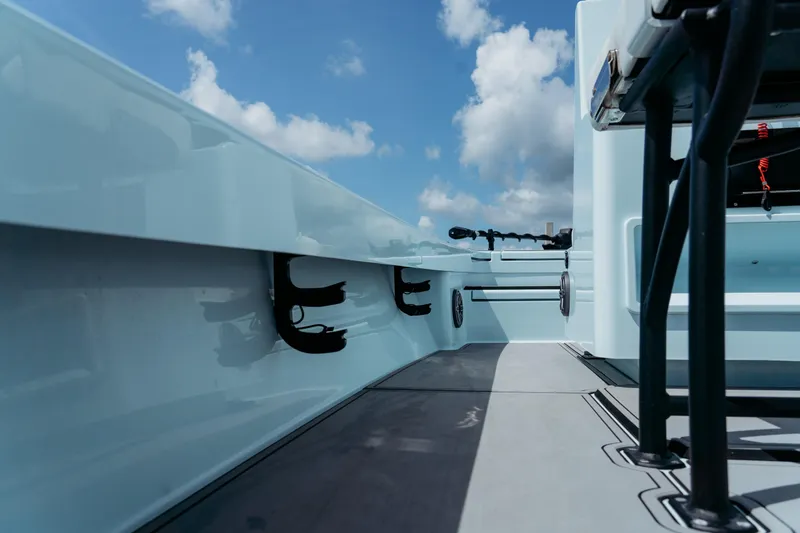 Slide: The Image of 2025 East Cape 25 Hybrid boat interior with rod holders and seating, under a blue sky. - 3