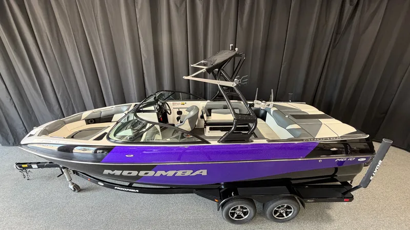 Slide: The Image of A 2016 Moomba Mojo boat on a trailer, featuring purple and gray accents. - 1