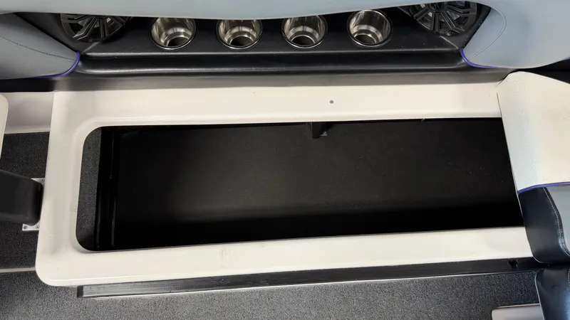 Slide: The Image of An open storage compartment on a boat with cup holders and speakers. - 32