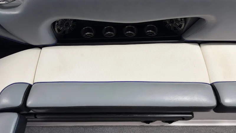 Slide: The Image of The rear seat of a 2016 Moomba Mojo with gray and white upholstery and speakers. - 48