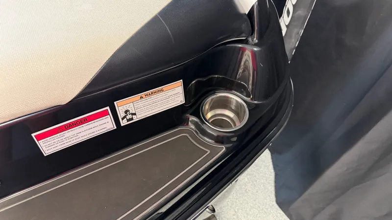 Slide: The Image of Close-up of a boat seat with a cup holder and warning labels. - 11