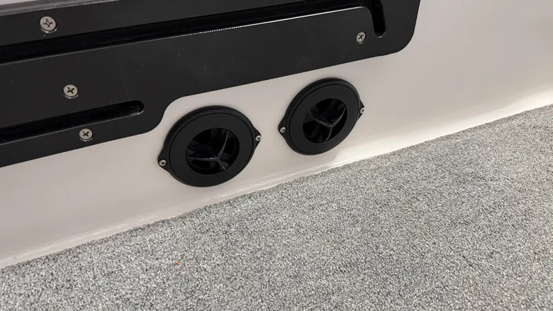 Slide: The Image of Two black vents are installed in a white wall, surrounded by gray carpet flooring. - 42