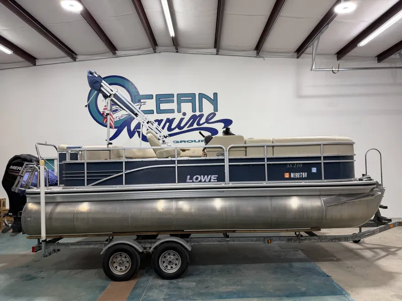 The Image of 2014 Lowe SS 210 pontoon boat in a storage facility. - 1