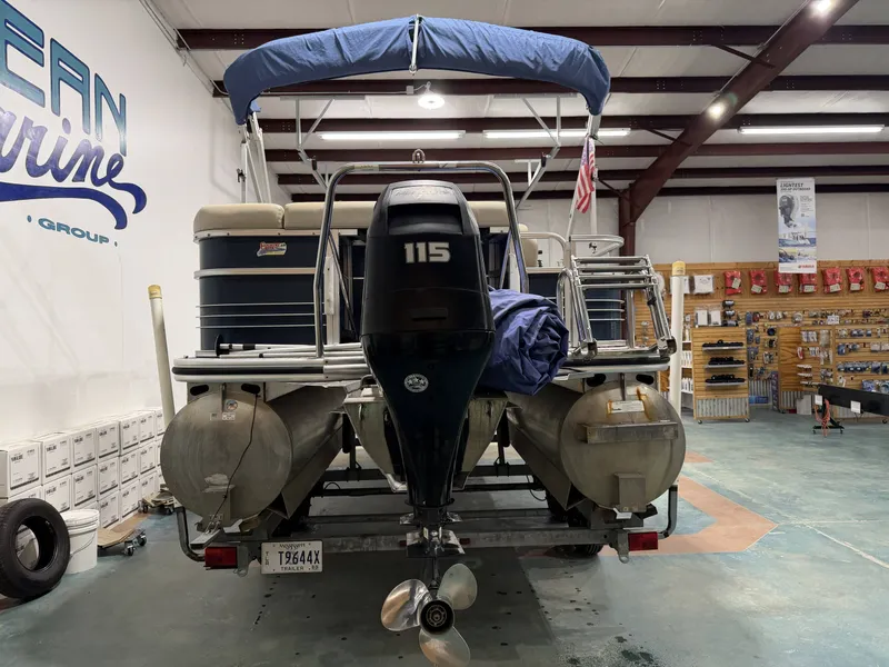 Slide: The Image of 2014 Lowe SS 210 pontoon boat in showroom with outboard motor. - 6