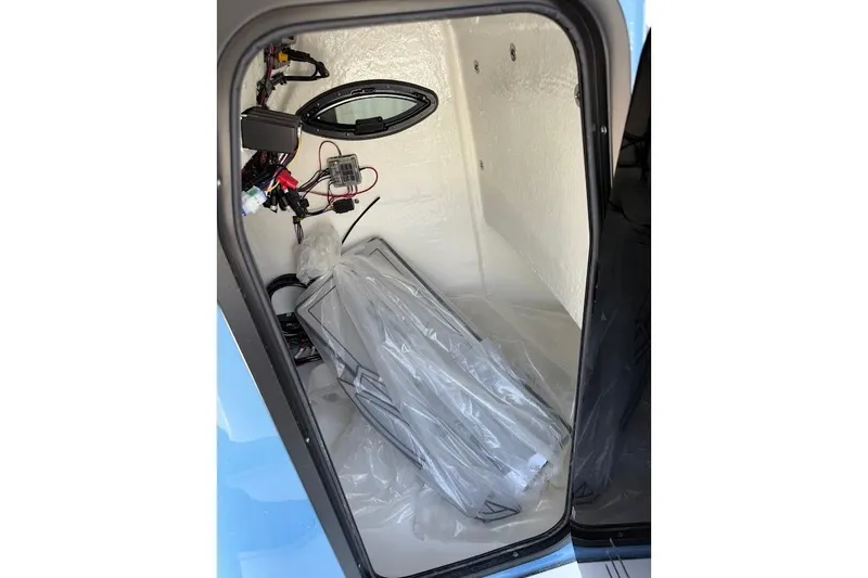 Slide: The Image of Interior view of 2026 Sea Pro 250 Bay boat compartment with wiring and equipment. - 15