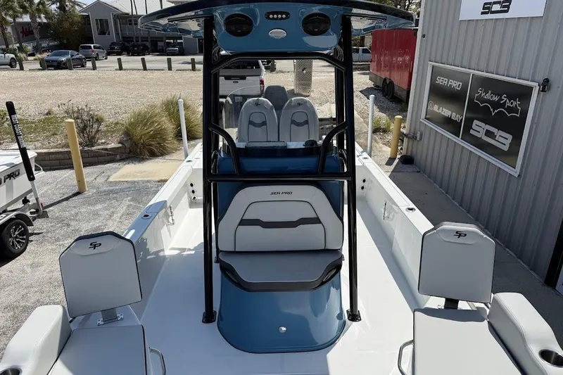 Slide: The Image of 2026 Sea Pro 250 Bay boat interior with seating and console, parked outdoors. - 20