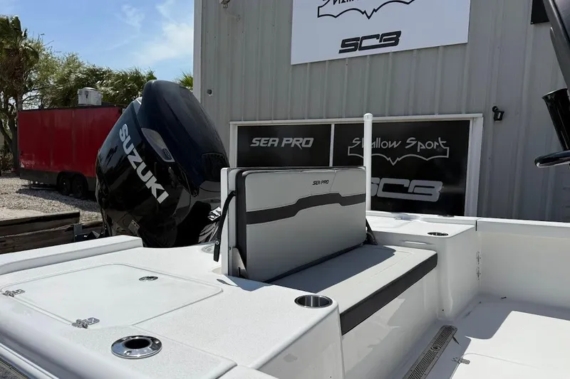 Slide: The Image of 2026 Sea Pro 250 Bay boat with Suzuki engine, docked near a building. - 6
