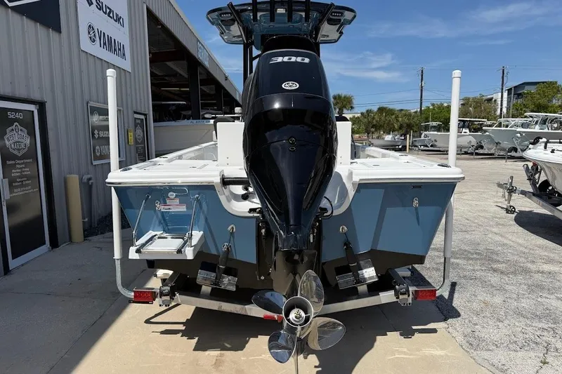 Slide: The Image of 2026 Sea Pro 250 Bay boat with powerful outboard motor, parked at a marine dealership. - 8