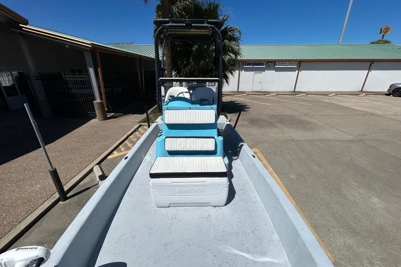 Slide: The Image of 2022 Stoner Super Cat boat with seating and Igloo cooler in a parking lot. - 12