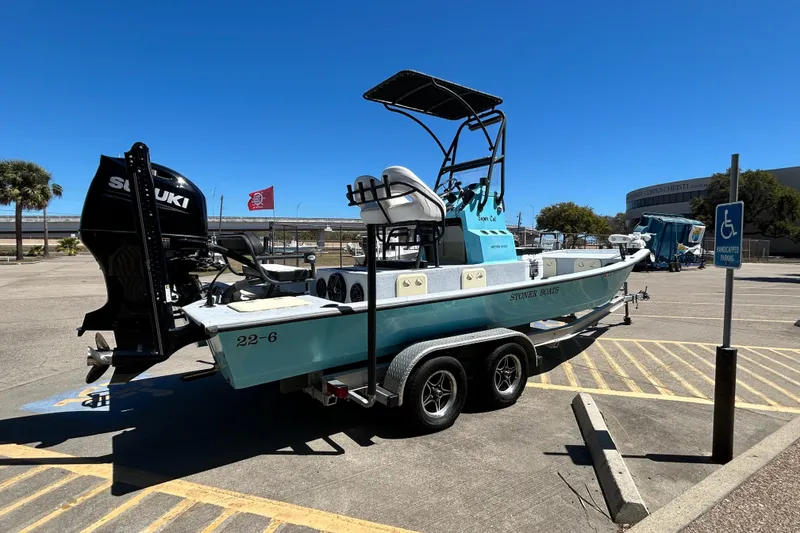 Slide: The Image of 2022 Stoner Super Cat boat on trailer in parking lot, featuring Suzuki engine. - 4