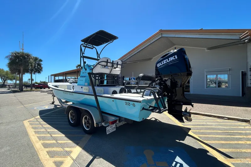 Slide: The Image of 2022 Stoner Super Cat boat on trailer with Suzuki outboard motor in parking lot. - 6
