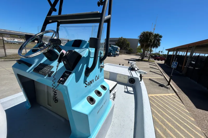 Slide: The Image of Blue 2022 Stoner Super Cat boat dashboard with steering wheel and controls. - 8