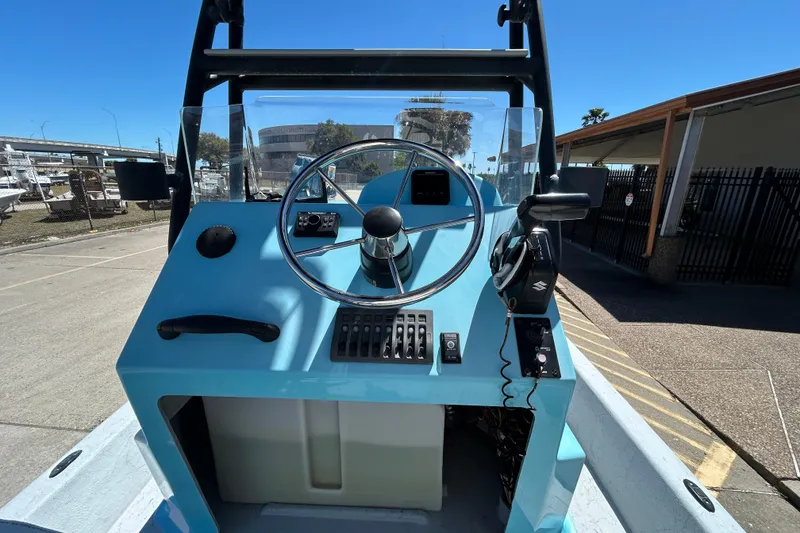 Slide: The Image of Control console of a 2022 Stoner Super Cat boat under clear blue skies. - 9