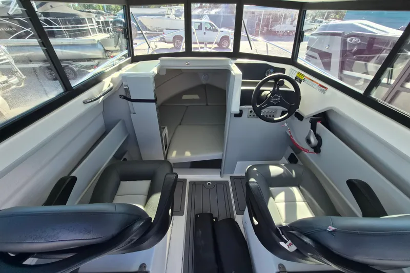 Slide: The Image of 2026 Arima 21 HT Sea Ranger boat deck view with parked vehicles in background. - 11