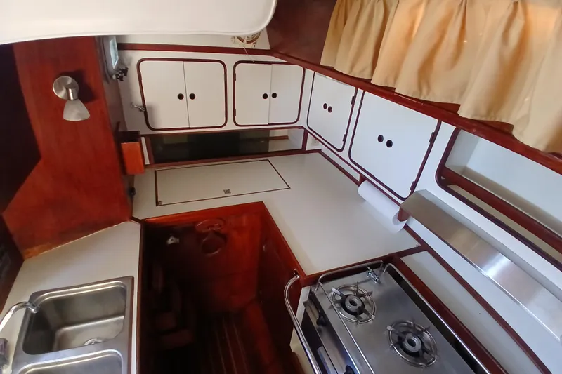 Slide: The Image of 1981 Gulfstar 44 yacht kitchen with stove, sink, and storage cabinets. - 11
