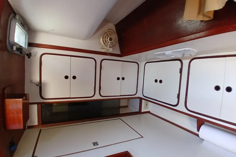 Slide: The Image of Interior of 1981 Gulfstar 44 sailboat with white cabinets and wooden trim. - 12