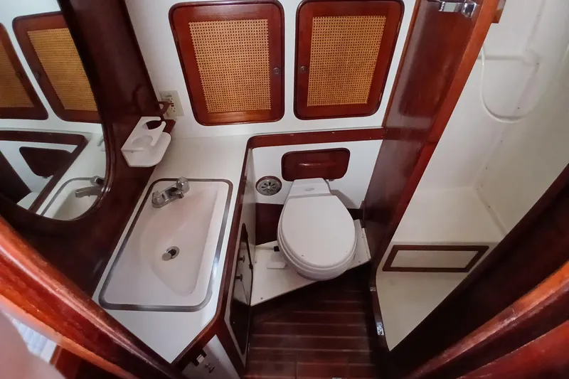 Slide: The Image of 1981 Gulfstar 44 yacht bathroom with sink, toilet, and wooden cabinetry. - 29