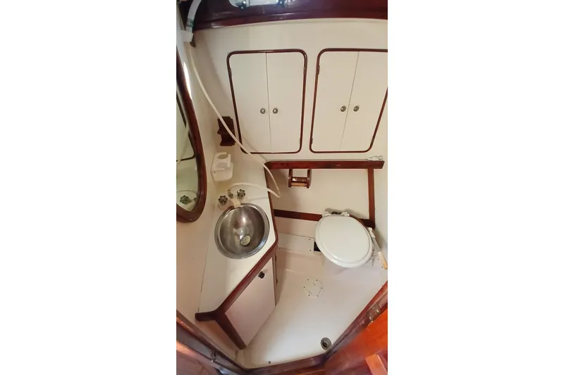 Slide: The Image of 1981 Gulfstar 44 yacht bathroom with sink, toilet, and storage cabinets. - 33