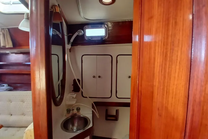 Slide: The Image of Interior of 1981 Gulfstar 44 yacht featuring wooden cabinetry and compact bathroom. - 36