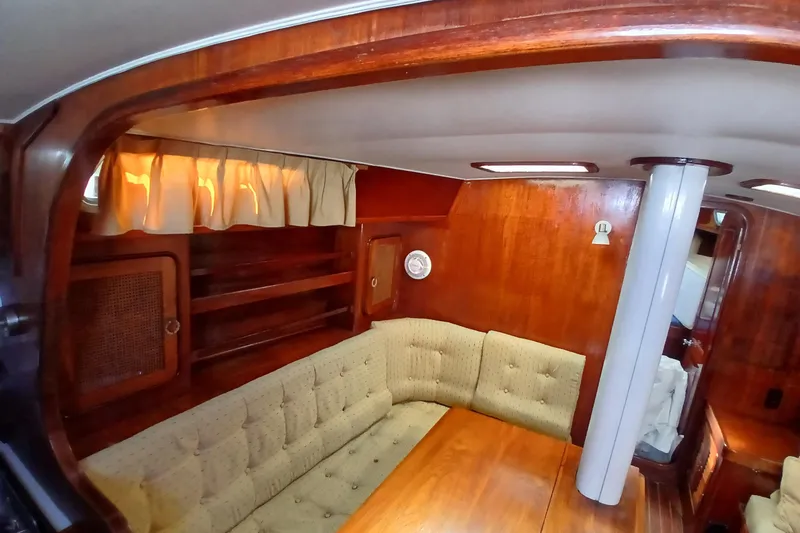 Slide: The Image of Interior of 1981 Gulfstar 44 yacht with wooden paneling and cushioned seating. - 5