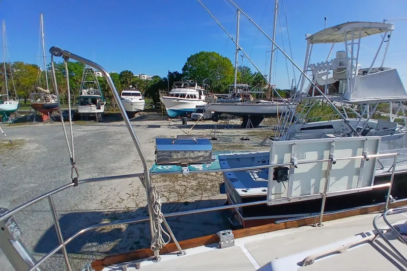Slide: The Image of Boats docked on land, including a 1981 Gulfstar 44, under a clear blue sky. - 50