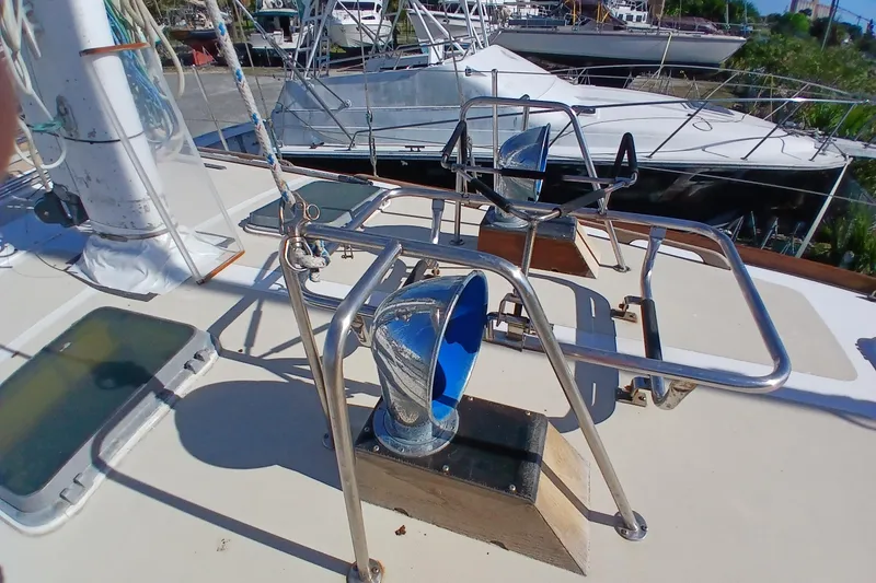 Slide: The Image of Deck of 1981 Gulfstar 44 sailboat with chrome fittings and hatches in a marina. - 53