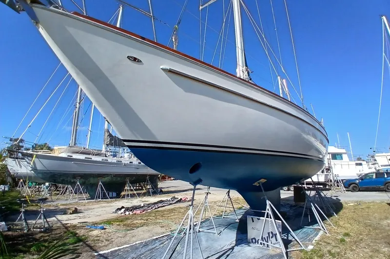 Slide: The Image of 1981 Gulfstar 44 sailboat on dry dock, blue hull, clear sky background. - 59