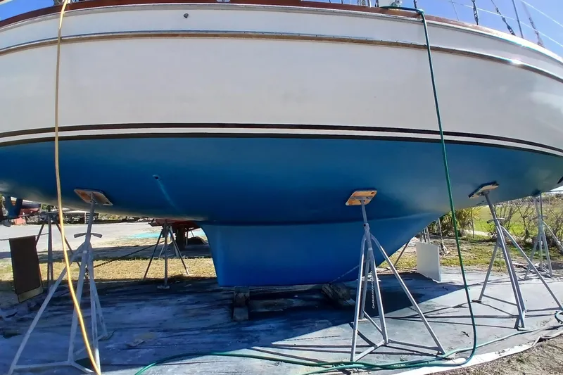 Slide: The Image of 1981 Gulfstar 44 sailboat on stands, blue hull, white upper section, outdoor setting. - 64
