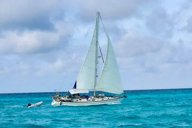 Slide: The Image of 1981 Gulfstar 44 sailboat cruising on turquoise ocean waters under cloudy skies. - 71