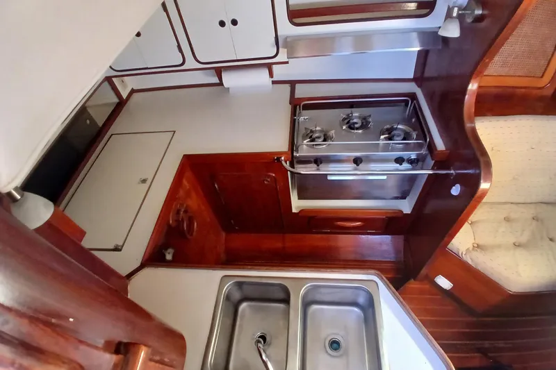 Slide: The Image of 1981 Gulfstar 44 yacht interior kitchen with stove, sink, and wooden cabinetry. - 9