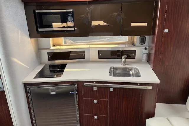 Slide: The Image of Compact kitchen in a 2019 Monterey 355 Sport Yacht with modern appliances and sleek cabinetry. - 13