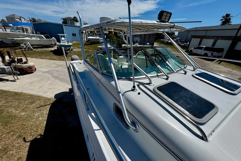 Slide: The Image of 2000 Glacier Bay 2670 Isle Runner boat docked in a marina under clear skies. - 15