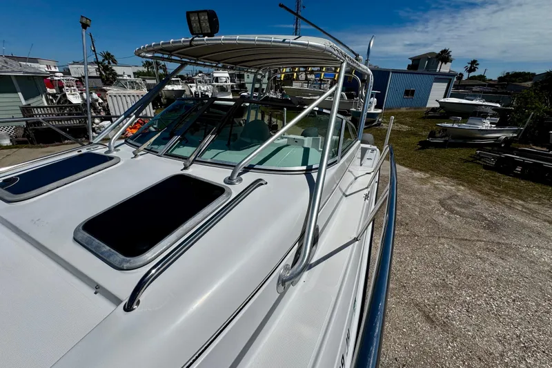 Slide: The Image of 2000 Glacier Bay 2670 Isle Runner boat with sleek design, docked outdoors under clear sky. - 17
