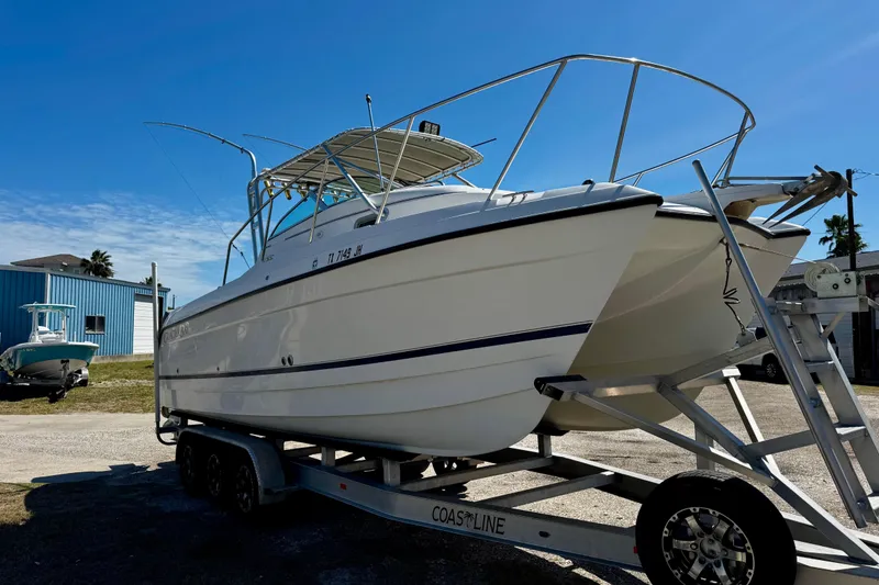 Slide: The Image of 2000 Glacier Bay 2670 Isle Runner boat on trailer under clear blue sky. - 2