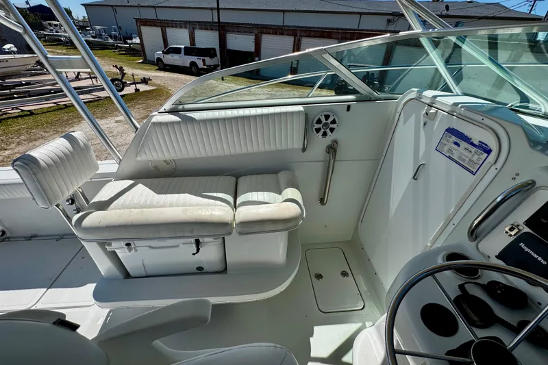 Slide: The Image of Interior view of a 2000 Glacier Bay 2670 Isle Runner boat, featuring white seating and steering area. - 24