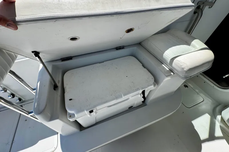 Slide: The Image of Open storage compartment on 2000 Glacier Bay 2670 Isle Runner boat, revealing a white cooler. - 25